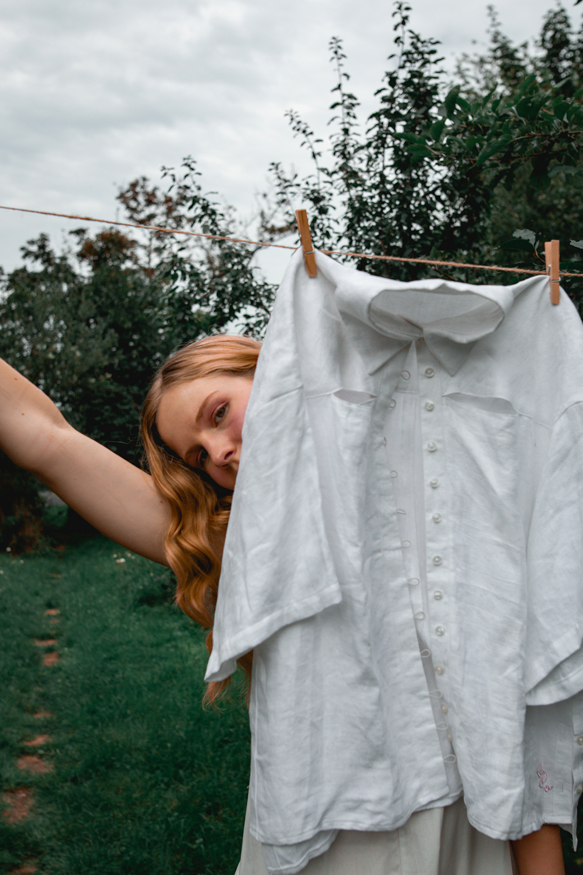 Model Posing Behind A Hanging Shirt